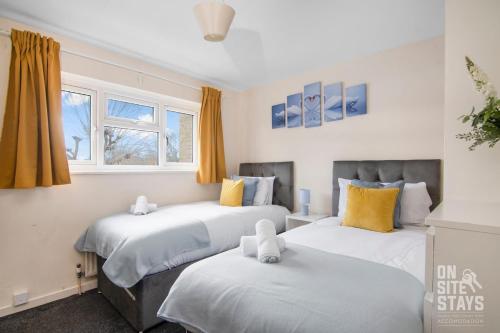 a bedroom with two beds and two windows at Contractors 4 Bed with Parking in Hatfield