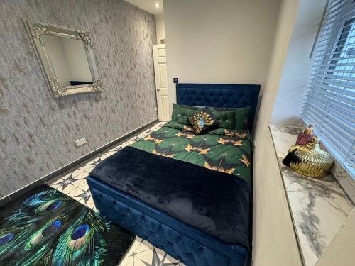 a bedroom with a blue bed in a room with a mirror at Gloucester - Apartment - Sleeps 2 - Parking - 97WS in Gloucester