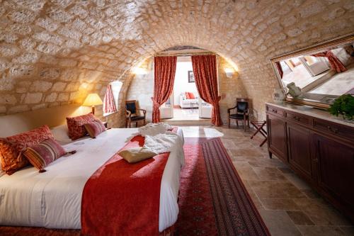 a bedroom with a large bed in a stone wall at Domaine de Saint-Géry - Teritoria in Lascabanes
