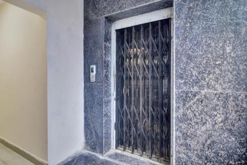 a door in a stone wall with a metal gate at Hotel O Shri Ganesh Near By Himayatnagar,Ashok Nagar,RTC X Roads in Hyderabad