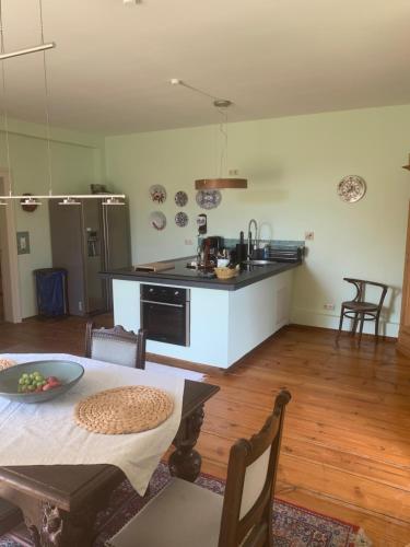 a living room with a table and a kitchen at Gutshaus Schwarzenhof in Dargun