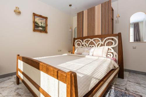 a bedroom with a large wooden bed in a room at Ąžuolo vila in Karklė