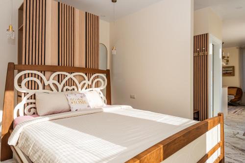 a bedroom with a large bed with a wooden headboard at Ąžuolo vila in Karklė