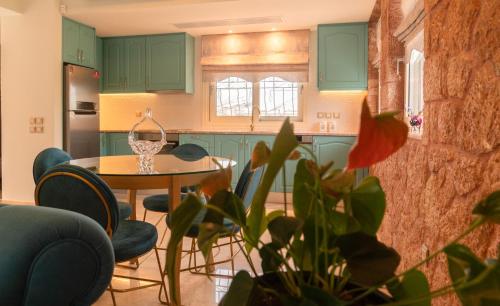 a kitchen with green cabinets and a table and chairs at 99 Luxury Exotic Villas in Nafplio