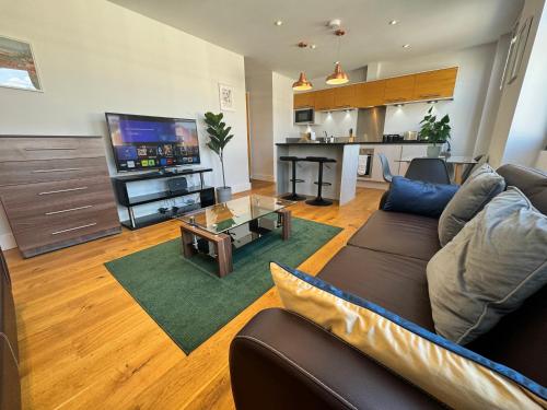 a living room with a couch and a tv at Twickenham Fraser Apartments in Twickenham