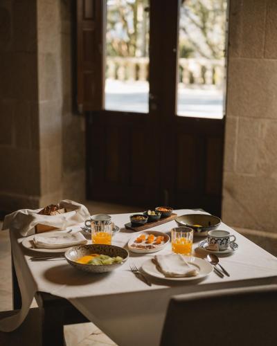 Una mesa con platos de comida y bebidas sobre ella. en Pazo Arretén, en Padrón