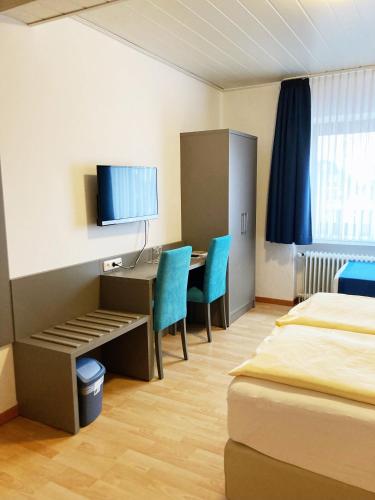 a hotel room with a desk and a table and chairs at Familien- und Aparthotel Strandhof in Butjadingen OT Tossens