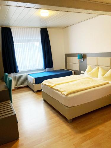 a hotel room with two beds and a window at Familien- und Aparthotel Strandhof in Butjadingen OT Tossens