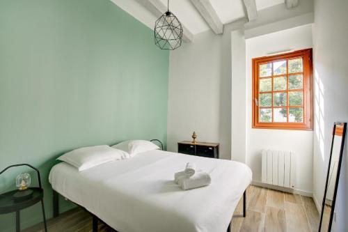 - une chambre dotée d'un lit blanc avec un animal rembourré dans l'établissement La cabane - A l Ombre des vieilles poutres, à Tours