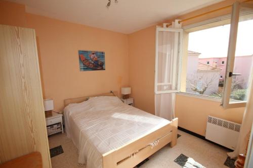 une chambre avec un lit et une grande fenêtre dans l'établissement Belle maison de vacances proche du centre et des plages, 8 couchages, vue mer, 80m de la mer de PORTIRAGNES PLAGE LXRM21, à Portiragnes