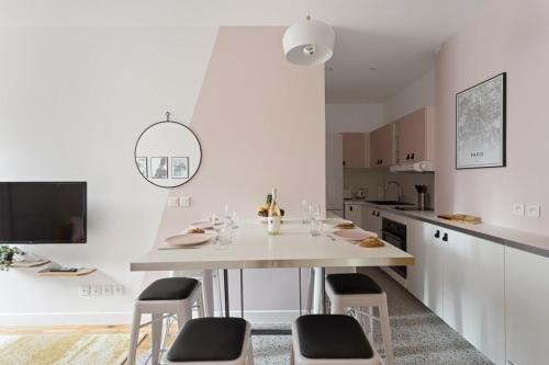 une cuisine blanche avec une table et des chaises blanches dans l'établissement Pink Design 2BDR Flat in the Heart of Bastille, à Paris