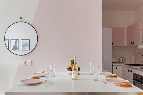 - une cuisine blanche avec une table et des verres à vin dans l'établissement Pink Design 2BDR Flat in the Heart of Bastille, à Paris