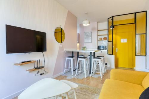 un salon avec un canapé et une télévision sur un mur dans l'établissement Pink Design 2BDR Flat in the Heart of Bastille, à Paris