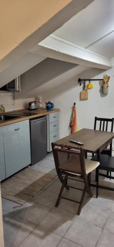 une cuisine avec une table en bois et une salle à manger dans l'établissement Cosy studio Clichy Levallois, à Clichy