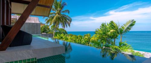 a swimming pool with a view of the ocean at Surin Beach Oceanfront Villa with Ocean and Beach views in Surin Beach