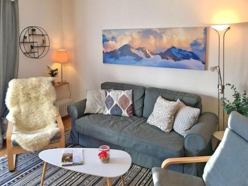 un salon avec un canapé et une chaise dans l'établissement Ferienhaus Nr 30, Kategorie Komfort Plus, Feriendorf Hochbergle, Allgäu, à Lechbruck am See