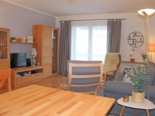 - un salon avec une table, un canapé et une télévision dans l'établissement Ferienhaus Nr 30, Kategorie Komfort Plus, Feriendorf Hochbergle, Allgäu, à Lechbruck am See