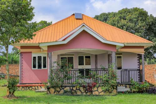 a small pink house with an orange roof at Tranquillity comfort home in Mukono