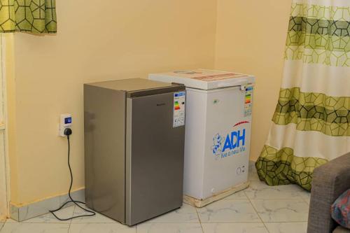 a refrigerator and a water cooler in a room at Tranquillity comfort home in Mukono