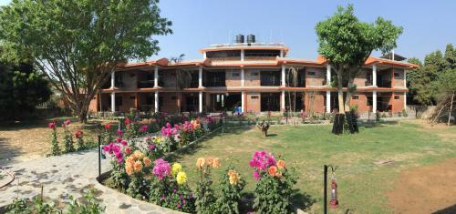 a house with a garden of flowers in front of it at Chautari Garden Resort in Sauraha