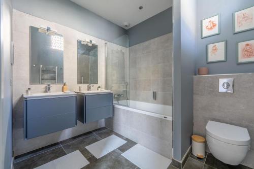 une salle de bain avec deux lavabos et une baignoire et des toilettes dans l'établissement Stunning family apartment, à Tours