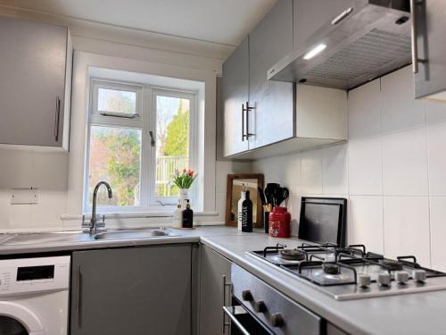 a white kitchen with a stove and a sink at Luxury and Stylish Ensuits in London