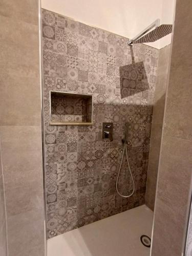 a bathroom with a shower with a tiled wall at Studio 49 - da Frank in Giardini Naxos