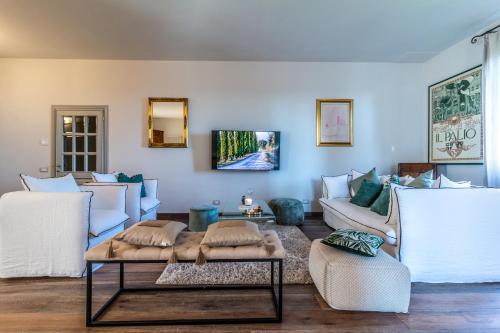 a living room with white couches and a table at Villa Porri by MMega in Siena