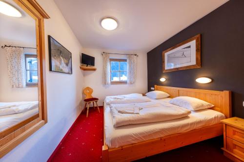 une chambre avec deux lits et un miroir dans l'établissement Schöneben Chalet Wiesenwald, à Wald im Pinzgau