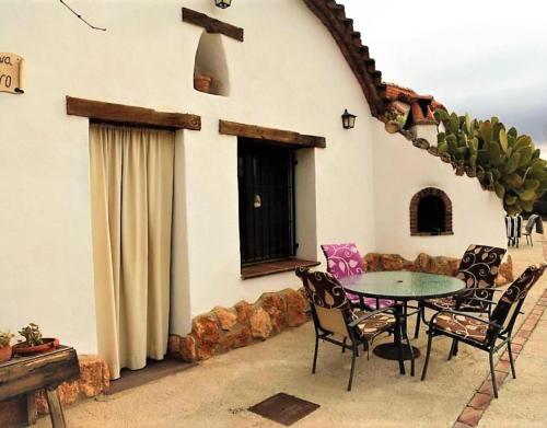 a patio with a table and chairs in front of a building at El Olivo in Benalúa de Guadix