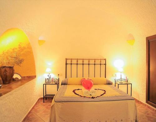 a bedroom with a bed with a heart on it at El Olivo in Benalúa de Guadix