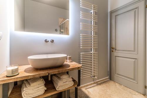 a bathroom with a white bowl sink on a wooden counter at Villa Porri by MMega in Siena