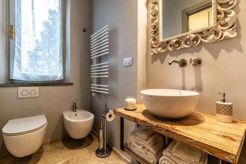 a bathroom with a sink and a toilet and a mirror at Villa Porri by MMega in Siena