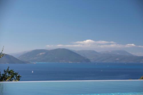a large body of water with mountains in the background at Brand new High-end villa Solar in Sivota
