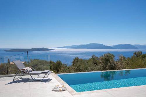 a villa with a swimming pool and a chair at Brand new High-end villa Solar in Sivota