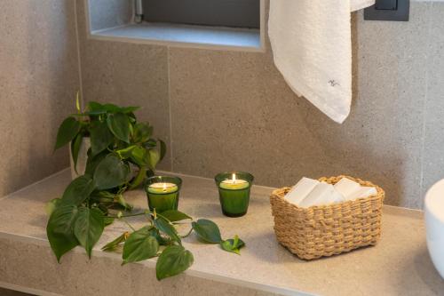 a bathroom counter with candles and a basket and a plant at Brand new High-end villa Solar in Sivota