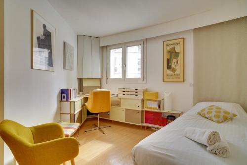 une chambre avec un lit, un bureau et une chaise dans l'établissement Bastille Apt design with AC terrace 5 people by Weekome, à Paris