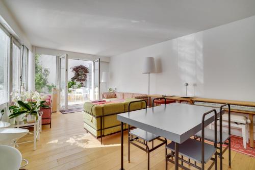 un salon avec une table et un canapé dans l'établissement Bastille Apt design with AC terrace 5 people by Weekome, à Paris