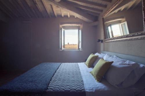 a bedroom with a bed with a mirror on the wall at Camere di Via Montebello in Castagneto Carducci