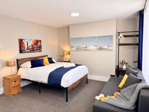 a bedroom with a bed and a couch at Luxury and Stylish Ensuits in London