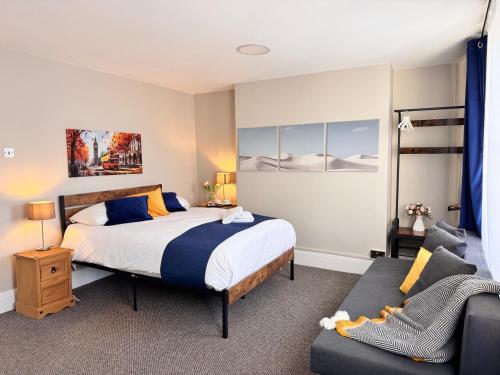 a bedroom with a bed and a couch at Luxury and Stylish Ensuits in London