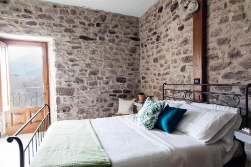 a bed in a room with a stone wall at Ca'Luni in Casola in Lunigiana