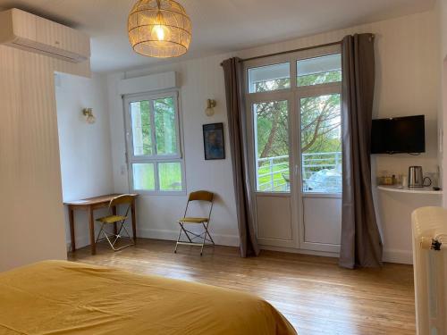 une chambre avec un lit et deux chaises et une fenêtre dans l'établissement 2 chambres 5 pers Domaine de Treuillaud, à Villers-les-Ormes