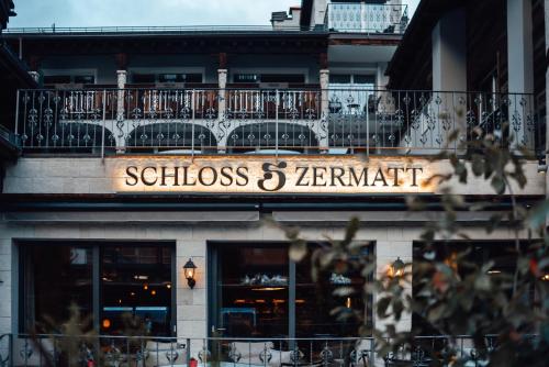 a sign for a restaurant on the side of a building at SCHLOSS Zermatt - CBD & Adaptogenic Spa and Sport Hotel in Zermatt