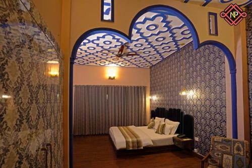 1 dormitorio con 1 cama en una habitación con un arco en Haveli Banquet & Resort, en Ajmer