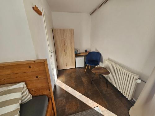 a bedroom with a bed and a chair and a desk at Karawanken Lodge in Faak am See