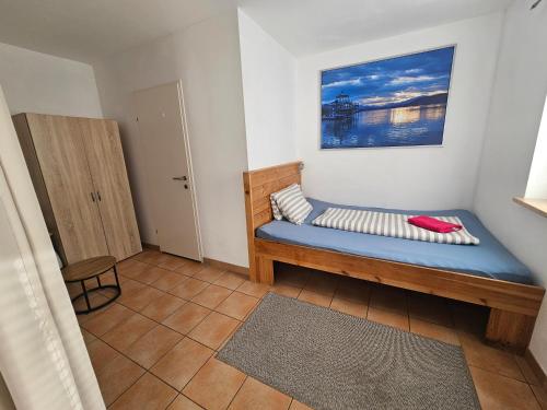 a small bedroom with a blue bed in a room at Karawanken Lodge in Faak am See