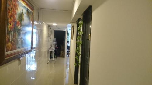 a hallway with a painting on the wall and a painting on the wall at Axis Hotel in Taiping