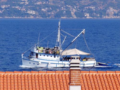 a boat in the water next to a building at Apartment Ennio in Povlja
