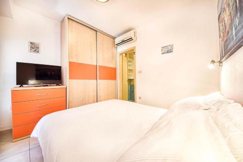 a bedroom with a bed and a flat screen tv at Apartment Ennio in Povlja